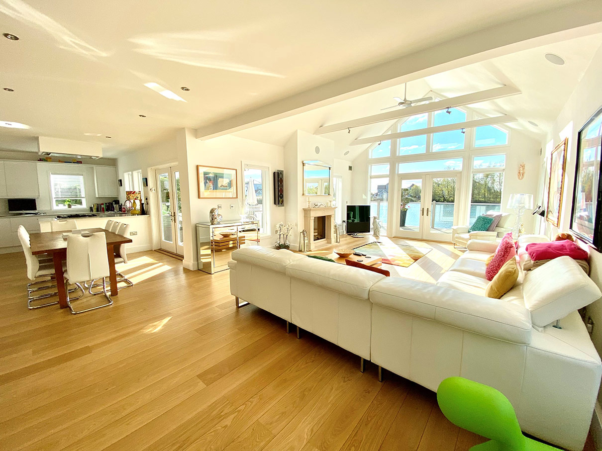 Grand living room interior with large white sofa and wooden floors