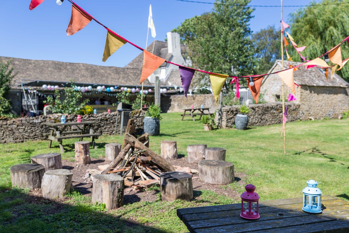 Photo of an outdoor firepit, old barn and bunting on a summer's day