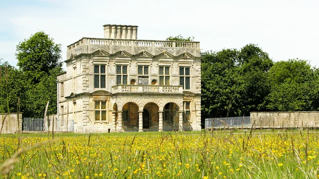 A summer meadow in front of a 17th century stone grandstand building