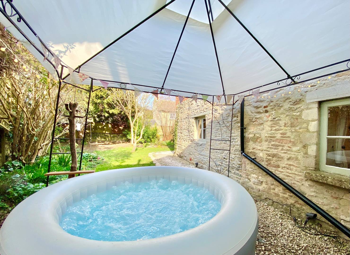 Hot tub under a gazebo in an English country garden