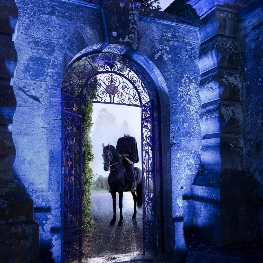 Photo of a pumpkin in a pumSpooky headless horseman in a castle doorway at night. Halloween activities for autumn half term